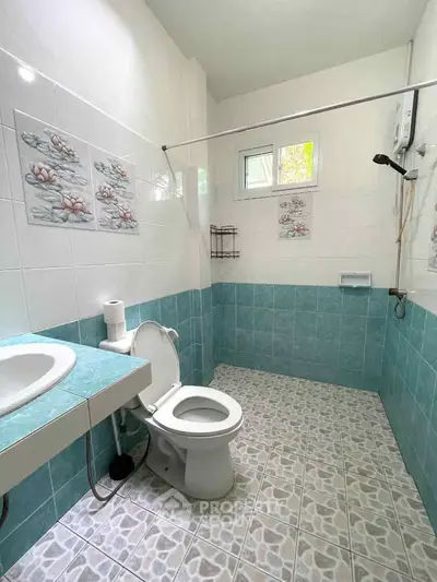 Bright and clean bathroom with modern fixtures and decorative tiles.