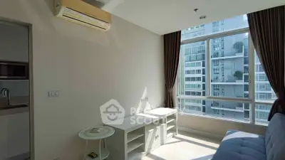 Bright living room with large window and modern air conditioning unit in a high-rise apartment.