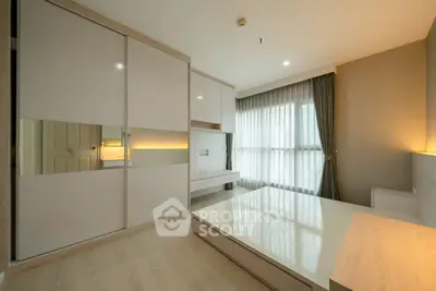 Modern bedroom with sleek built-in wardrobe and large window for natural light.