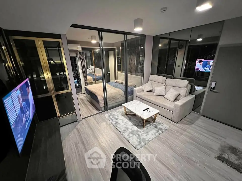 Modern studio apartment with glass partition, cozy living area, and stylish decor.