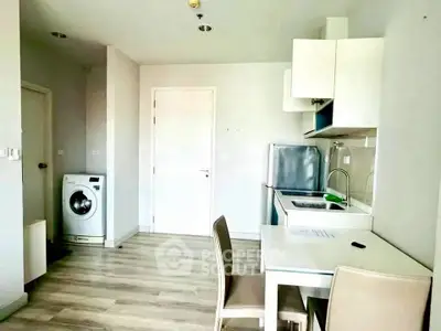 Modern kitchen with dining area and washing machine in a compact apartment