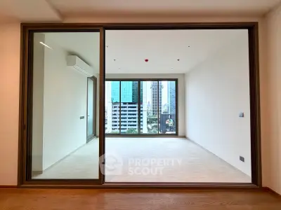 Spacious modern living room with large glass doors and city view