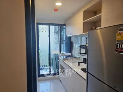 Modern kitchen with sleek appliances and balcony view in a stylish apartment.