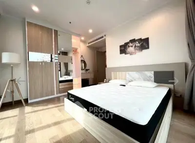 Spacious modern bedroom with stylish decor and ample natural light.