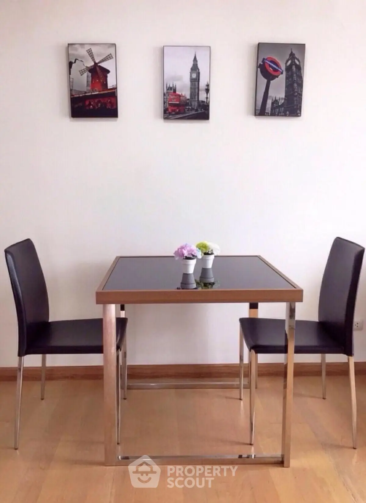 Modern dining area with sleek table and chairs, featuring stylish wall art.