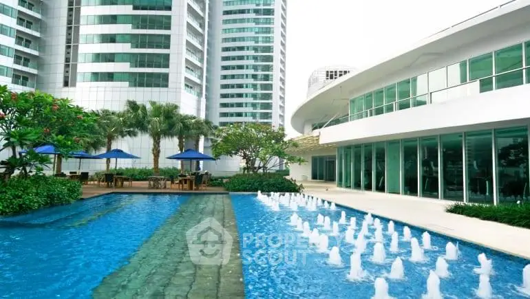 Luxurious apartment complex with stunning pool and modern architecture.