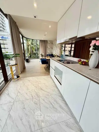 Modern open kitchen with sleek design and spacious living area in luxury apartment.