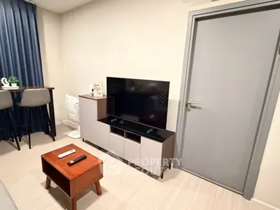 Modern living room with sleek TV stand and cozy seating area, perfect for relaxation.