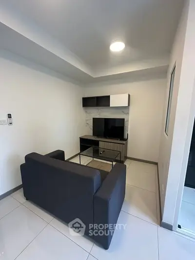 Modern living room with sleek furniture and TV setup, perfect for urban living.