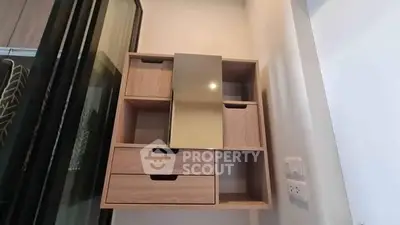 Modern wooden storage unit with mirror in stylish interior space.