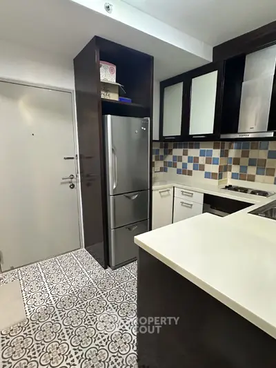 Modern kitchen with stylish tile flooring and stainless steel fridge