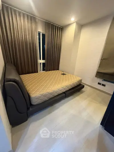 Modern bedroom with sleek design and cozy ambiance, featuring a comfortable bed and stylish curtains.