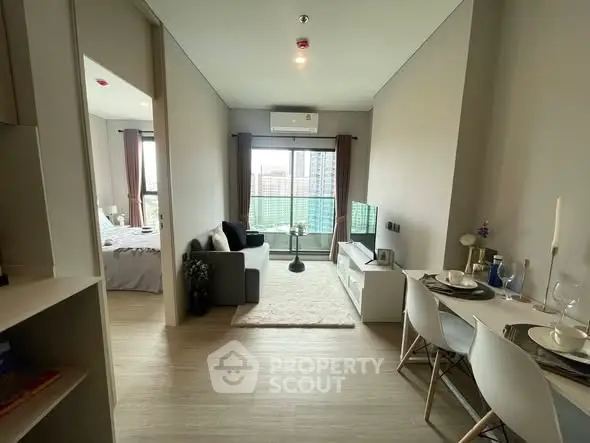 Modern apartment interior with open living and dining area, featuring a cozy balcony view.
