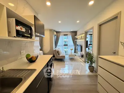 Modern open-plan kitchen and living room with sleek design and ample natural light.