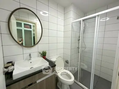 Modern bathroom with sleek shower and stylish vanity in contemporary apartment.