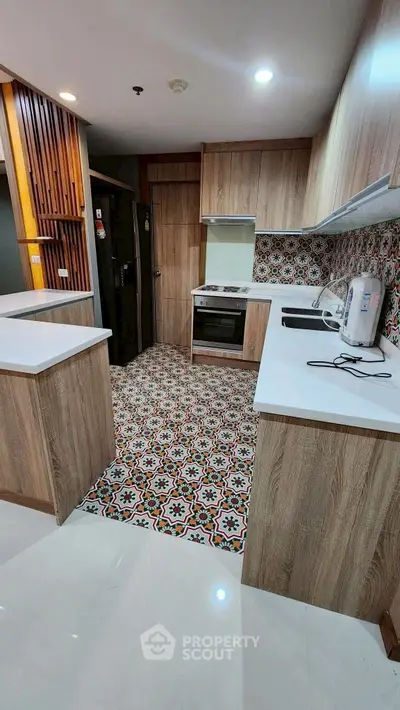 Modern kitchen with stylish patterned tiles and wooden cabinetry, featuring sleek appliances and ample counter space.