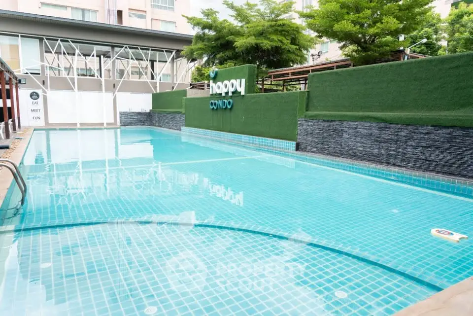 Luxurious condo pool area with modern design and lush greenery, perfect for relaxation and leisure.