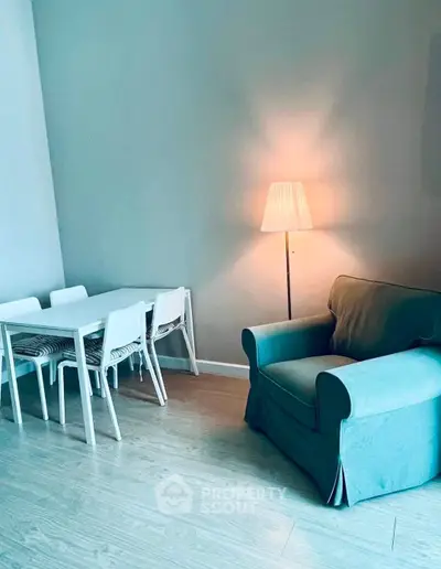 Cozy living room with modern dining set and comfortable armchair, perfect for relaxation and dining.