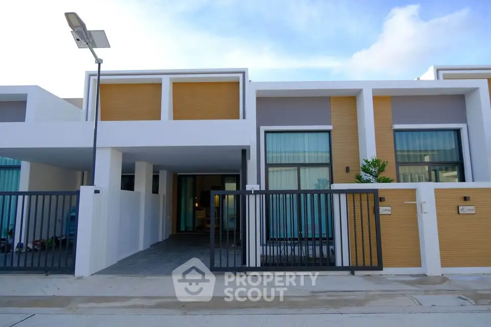 Modern townhouse exterior with sleek design and gated entrance, perfect for contemporary living.