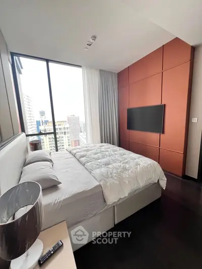 Modern bedroom with city view, featuring sleek design and cozy bedding in a high-rise apartment.