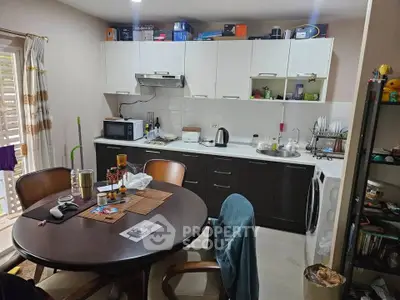 Cozy kitchen with dining table, modern appliances, and ample storage space.