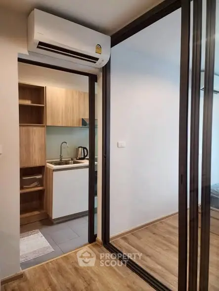 Modern compact kitchen with sleek design and glass partition in urban apartment