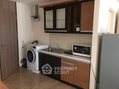 Compact kitchen with modern appliances and washing machine in cozy apartment