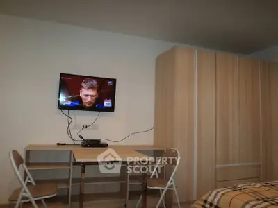 Modern bedroom with wall-mounted TV and wooden wardrobe, ideal for cozy living.