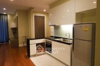 Modern kitchen with sleek cabinetry and stainless steel appliances in open layout.