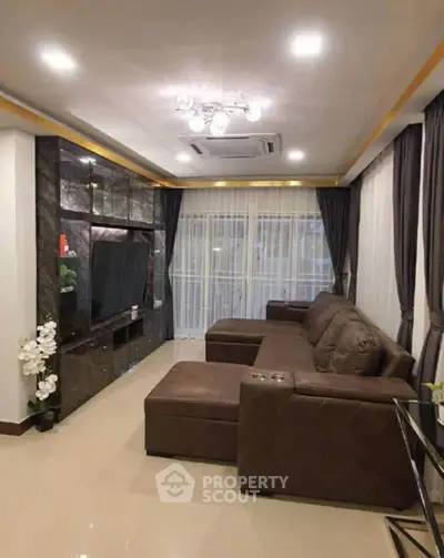 Luxurious living room with elegant brown sofa and modern entertainment center.