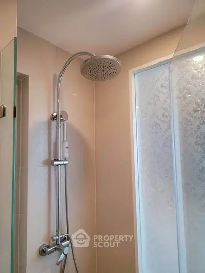 Modern bathroom with sleek showerhead and frosted glass door