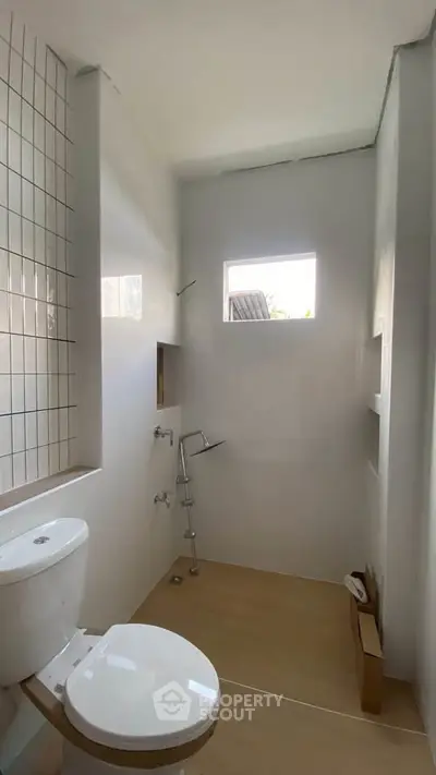 Modern minimalist bathroom with white tiles and natural light