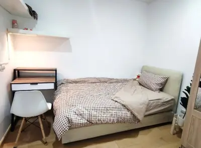 Cozy bedroom with modern desk and comfortable bed in stylish apartment.