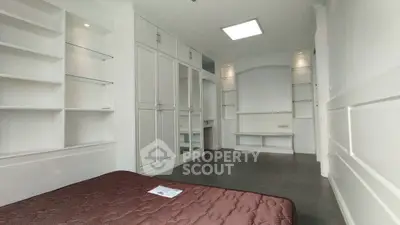 Spacious bedroom with built-in shelves and mirrored wardrobe