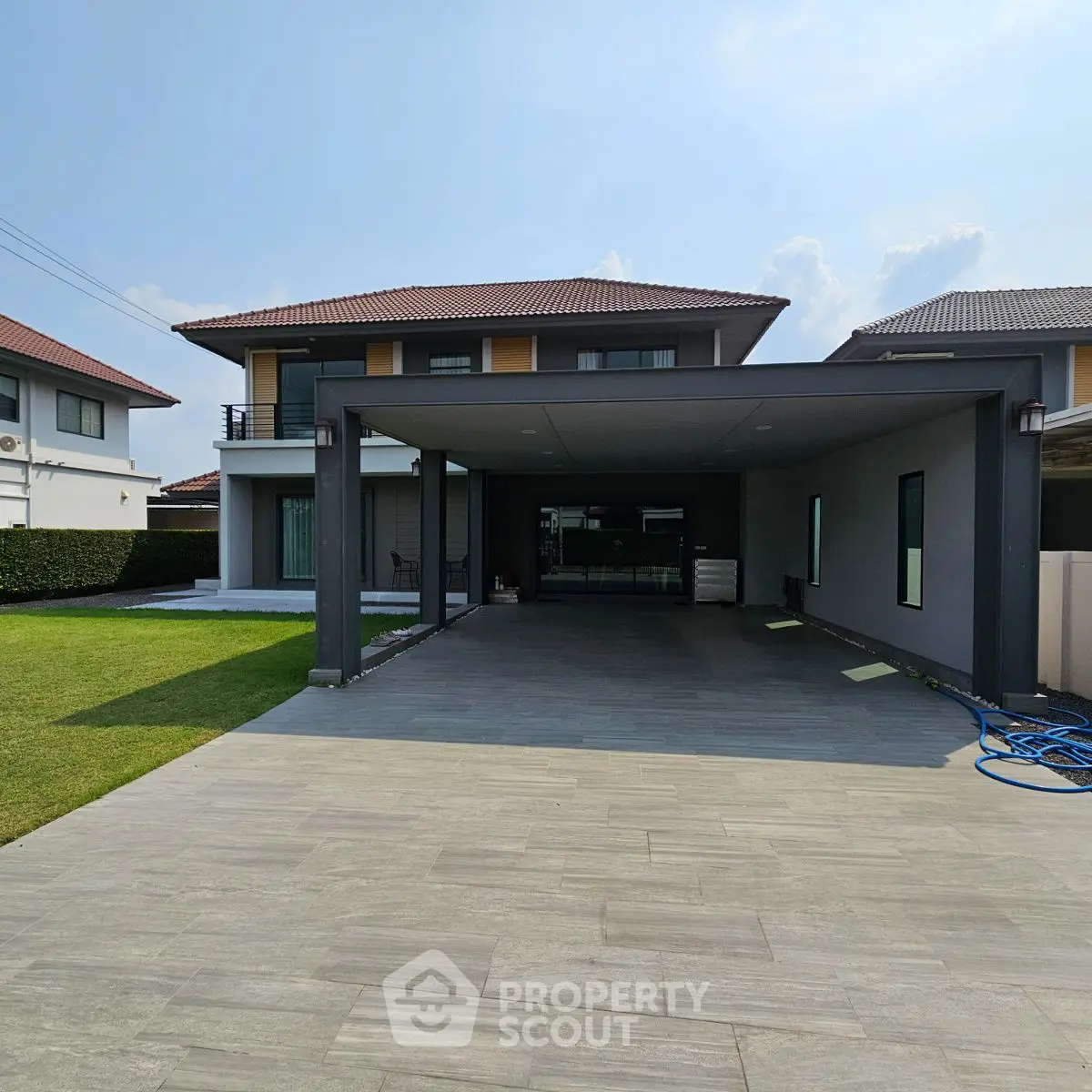 Modern two-story house with spacious driveway and manicured lawn in suburban setting.