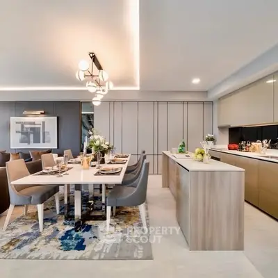 Modern open-plan kitchen and dining area with sleek design and elegant lighting.