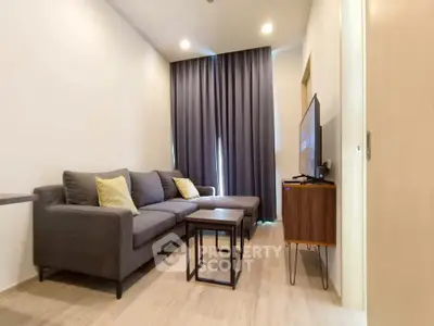 Modern living room with cozy gray sofa and flat-screen TV, perfect for relaxation.