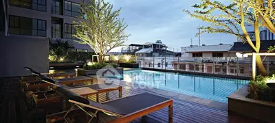 Luxurious rooftop pool with city views and modern lounge chairs, perfect for relaxation and entertainment.