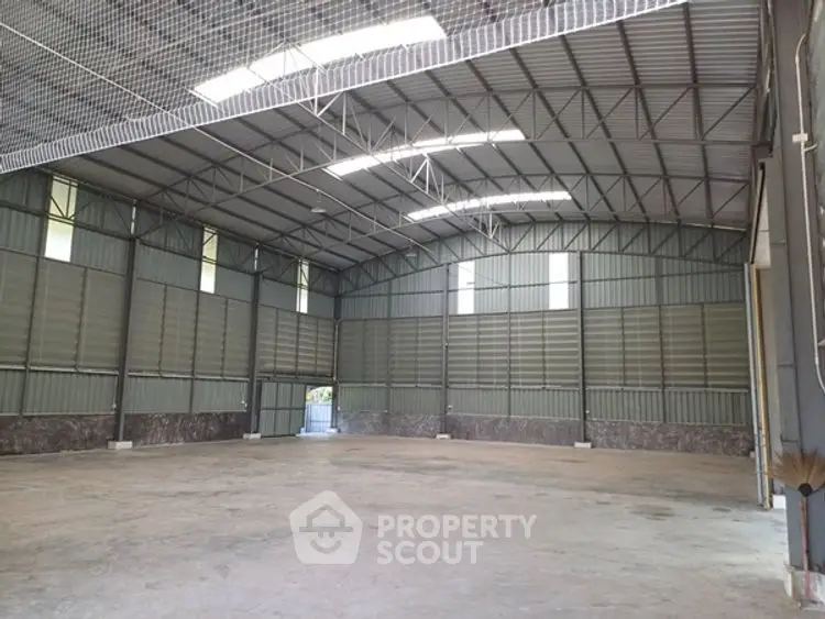 Spacious industrial warehouse with high ceilings and ample natural light.