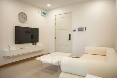 Modern living room with sleek furniture and wall-mounted TV, perfect for relaxation and entertainment.