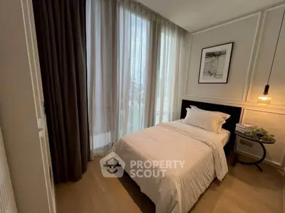 Cozy bedroom with elegant decor and large window offering natural light