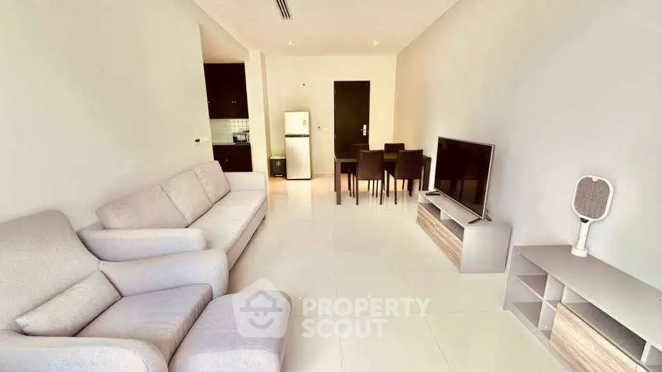 Spacious modern living room with sleek furniture and dining area in open layout.