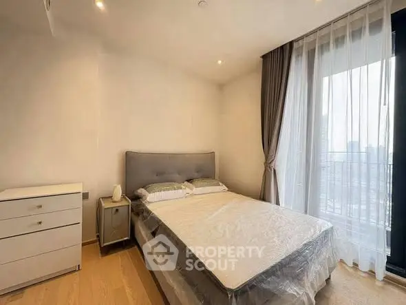 Modern bedroom with large window and elegant curtains in a stylish apartment.