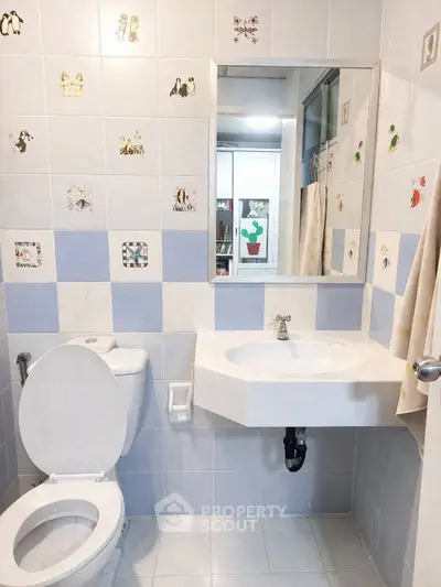 Charming bathroom with playful tile accents and modern fixtures, perfect for a cozy home.