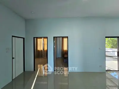 Spacious modern living room with glossy tiled floors and natural light