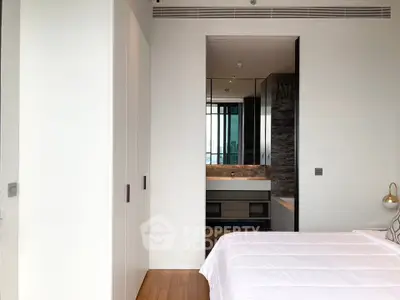 Modern bedroom with ensuite bathroom featuring sleek design and natural light.