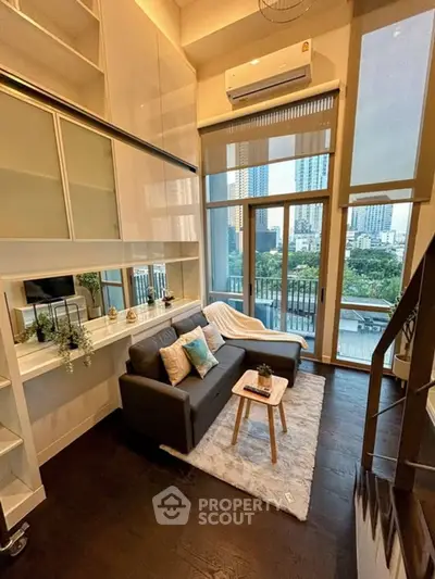 Modern living room with high ceilings and city view, featuring stylish decor and cozy seating area.