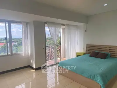 Spacious bedroom with large windows and balcony offering stunning views