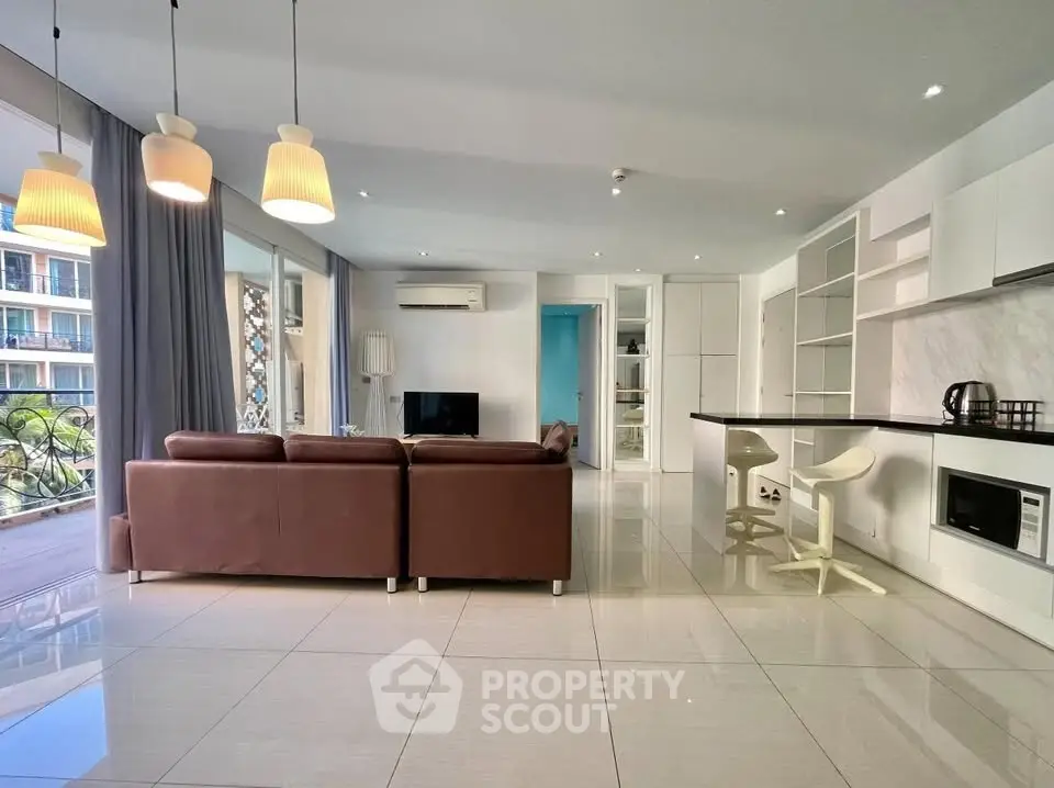 Spacious modern living room with open kitchen and large windows in luxury apartment.