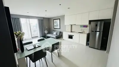 Modern open-plan living room with kitchen, dining area, and balcony view.